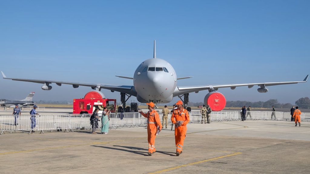 Large aircraft on display at Bengalurus Aero India Show with personnel and visitors.